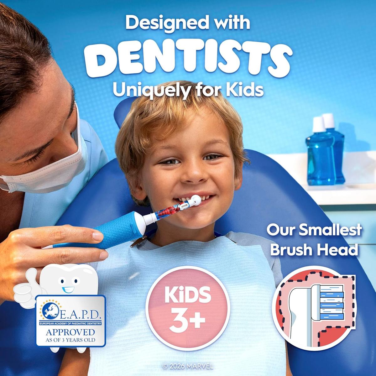 Dentist using a blue Marvel Spider-Man Oral-B electric toothbrush on a young child in a dental chair.