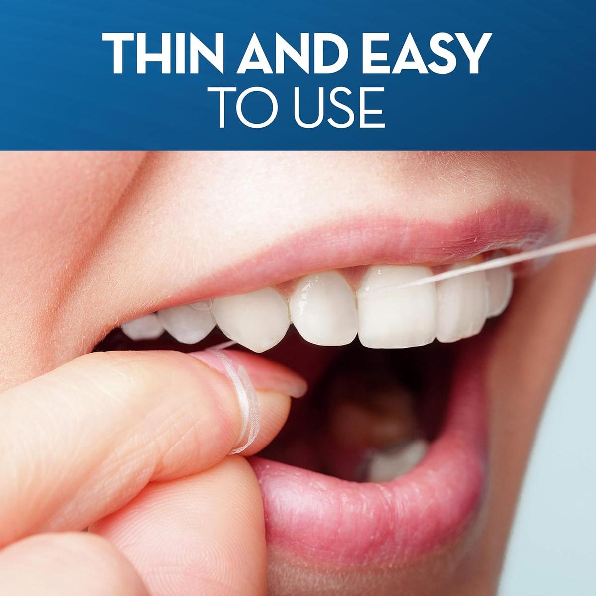 Close-up of a person using thin, unwaxed Oral-B dental floss to clean between white teeth and along the gum line.