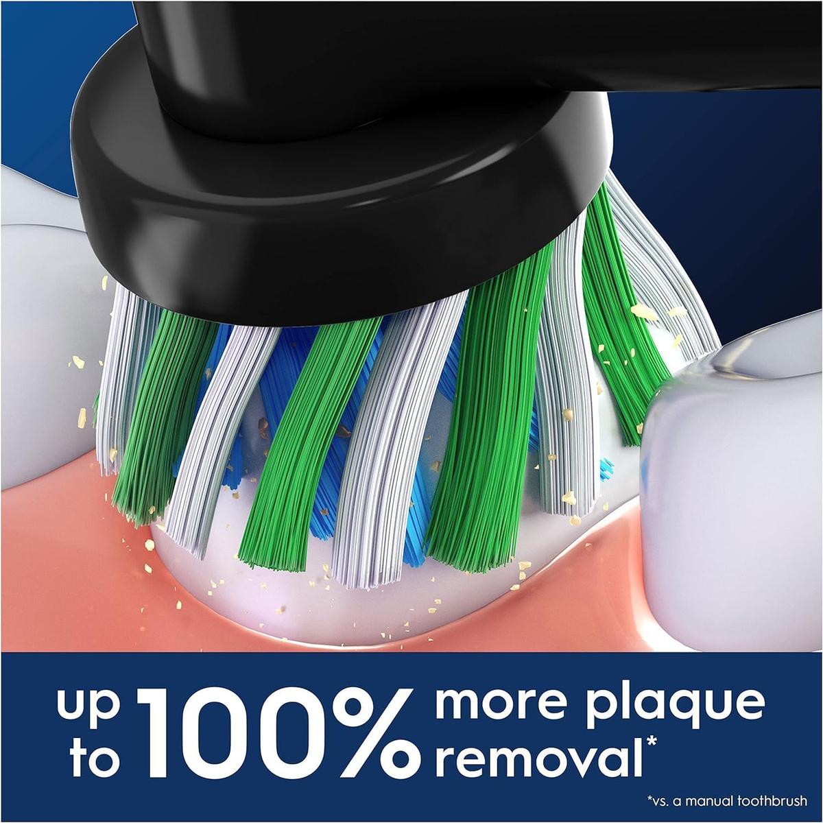 Black Oral-B Cross Action toothbrush head with X-shape green and white bristles cleaning plaque from a tooth.