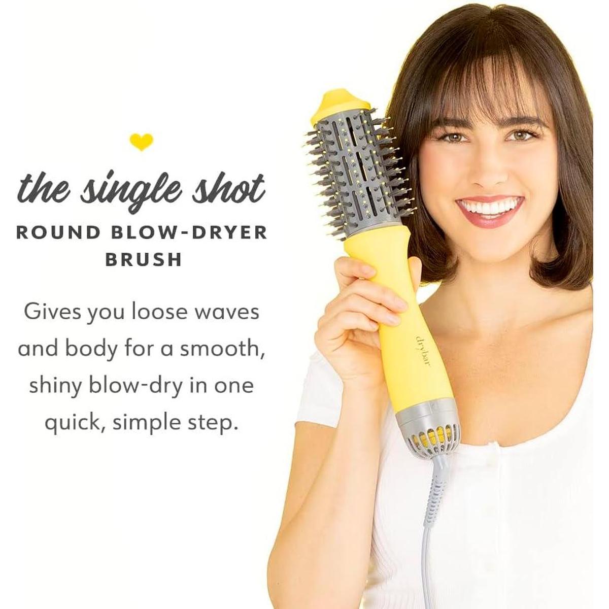 Woman holding a yellow and grey Drybar Single Shot round blow-dryer brush with text overlay.