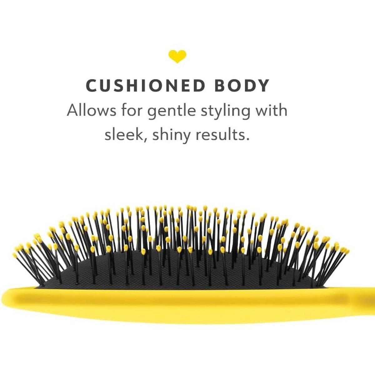 Drybar yellow paddle brush with flexible black nylon bristles and a cushioned base for gentle detangling and styling.