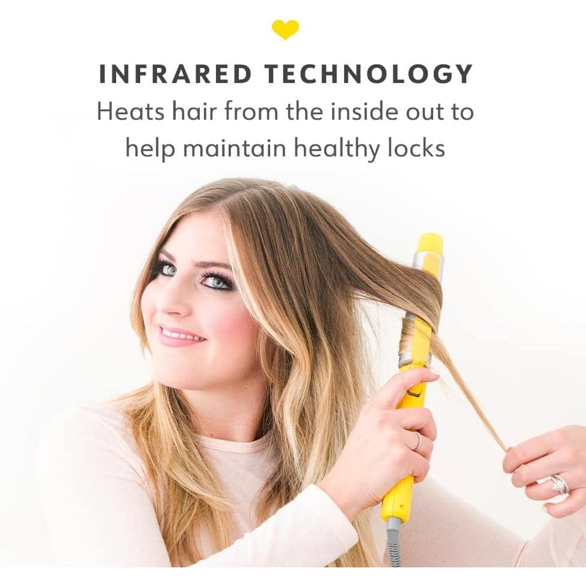 Woman using a bright yellow Drybar 3.2cm rotating curling iron to style her blonde hair with infrared technology.