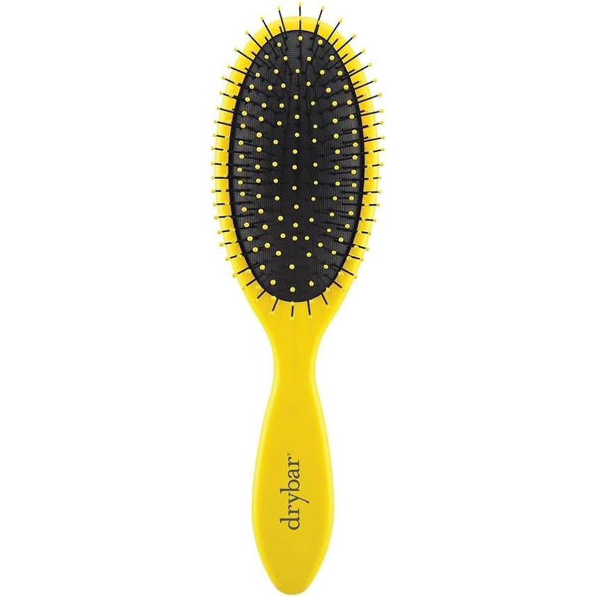 Drybar Super Lemon Drop detangling brush with a bright yellow handle and black oval head featuring flexible yellow bristles.