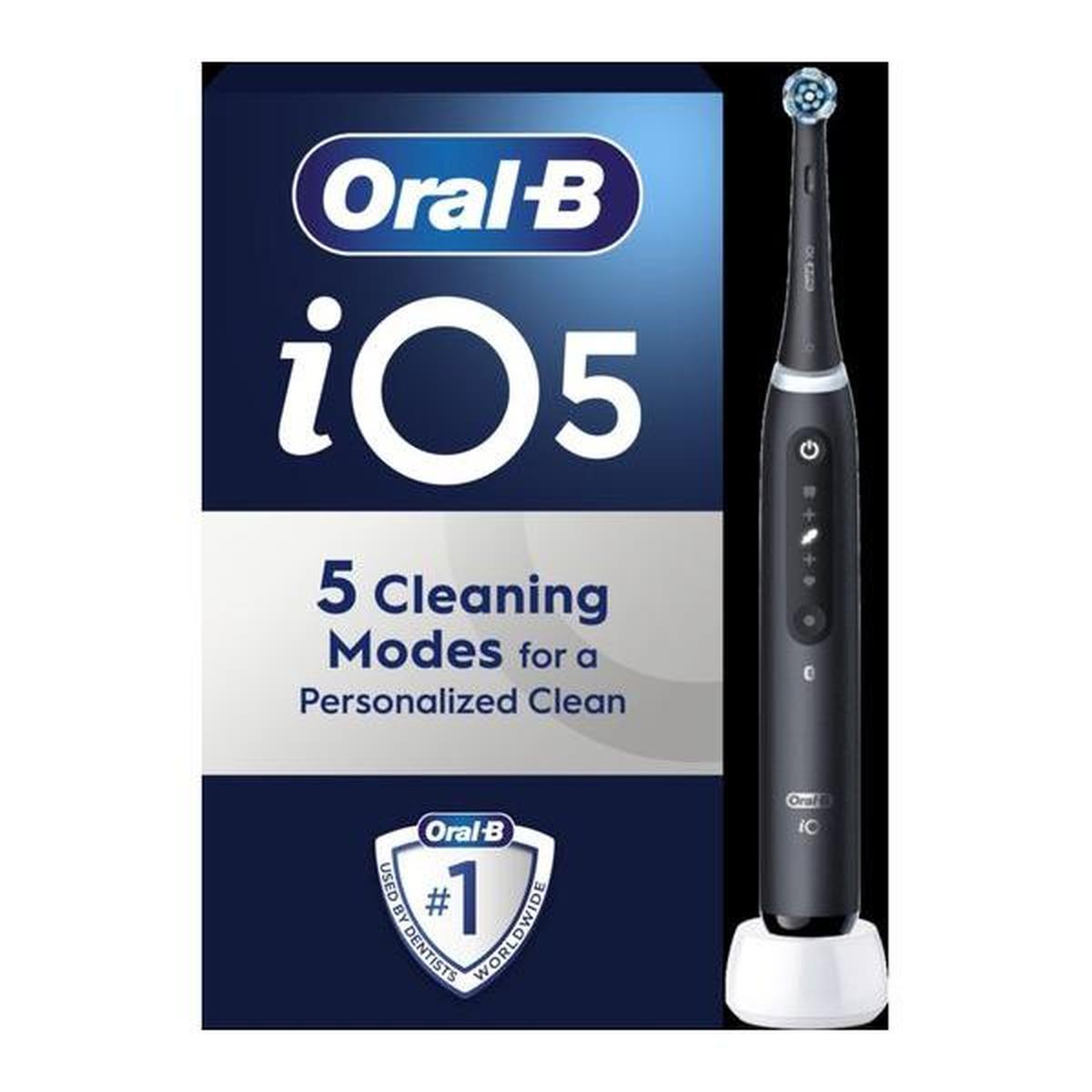 Oral-B iO 5 electric toothbrush in matte black with round brush head, digital display, and white charging base on box.