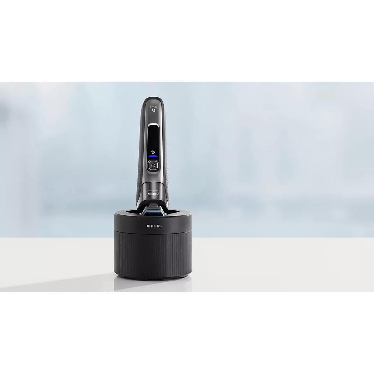 Black Philips electric shaver docked in a cylindrical Quick Clean Pod cleaning station on a white surface.
