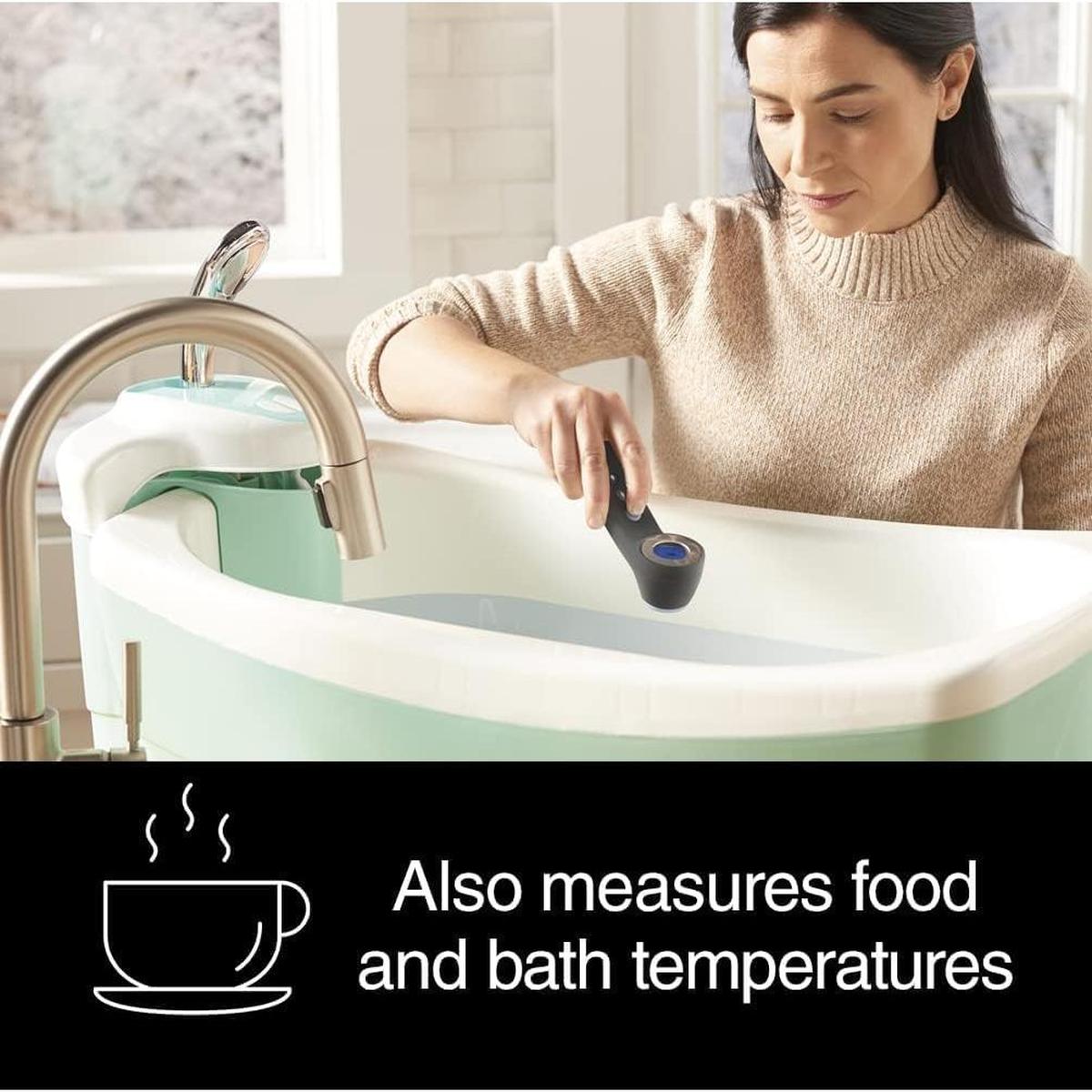 Woman using a black Braun Sensian 7 non-contact thermometer to measure the temperature of a baby bath.