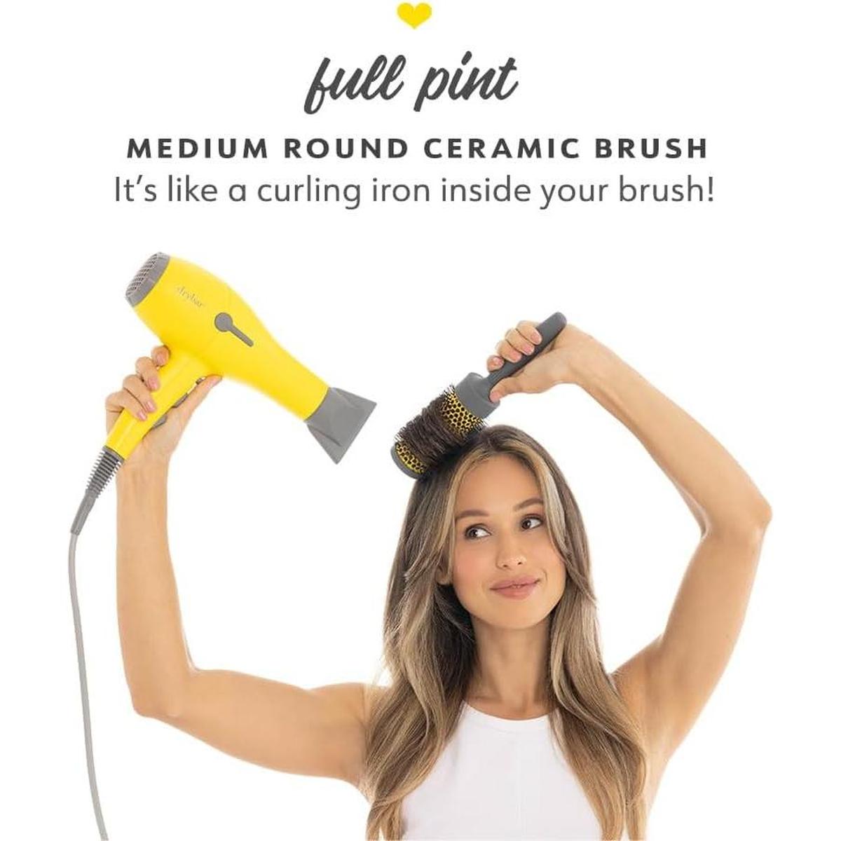 Woman using a yellow Drybar blow dryer and a medium round ceramic ionic hair brush to style her hair.