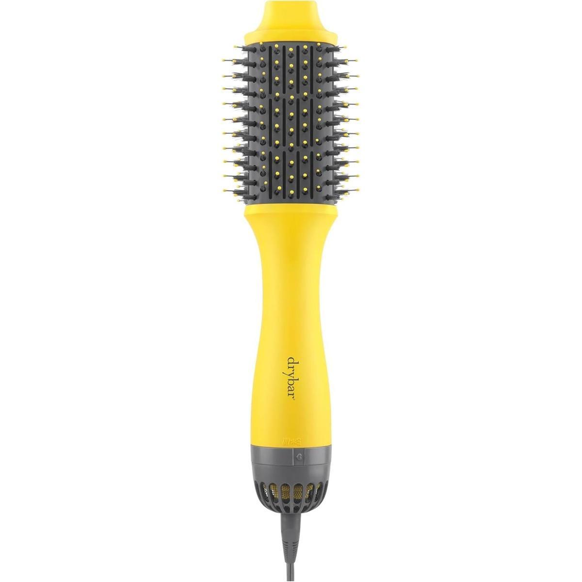 Drybar Double Shot 6.1cm oval blow-dryer brush in yellow with grey accents, featuring tufted bristles and an ergonomic handle.