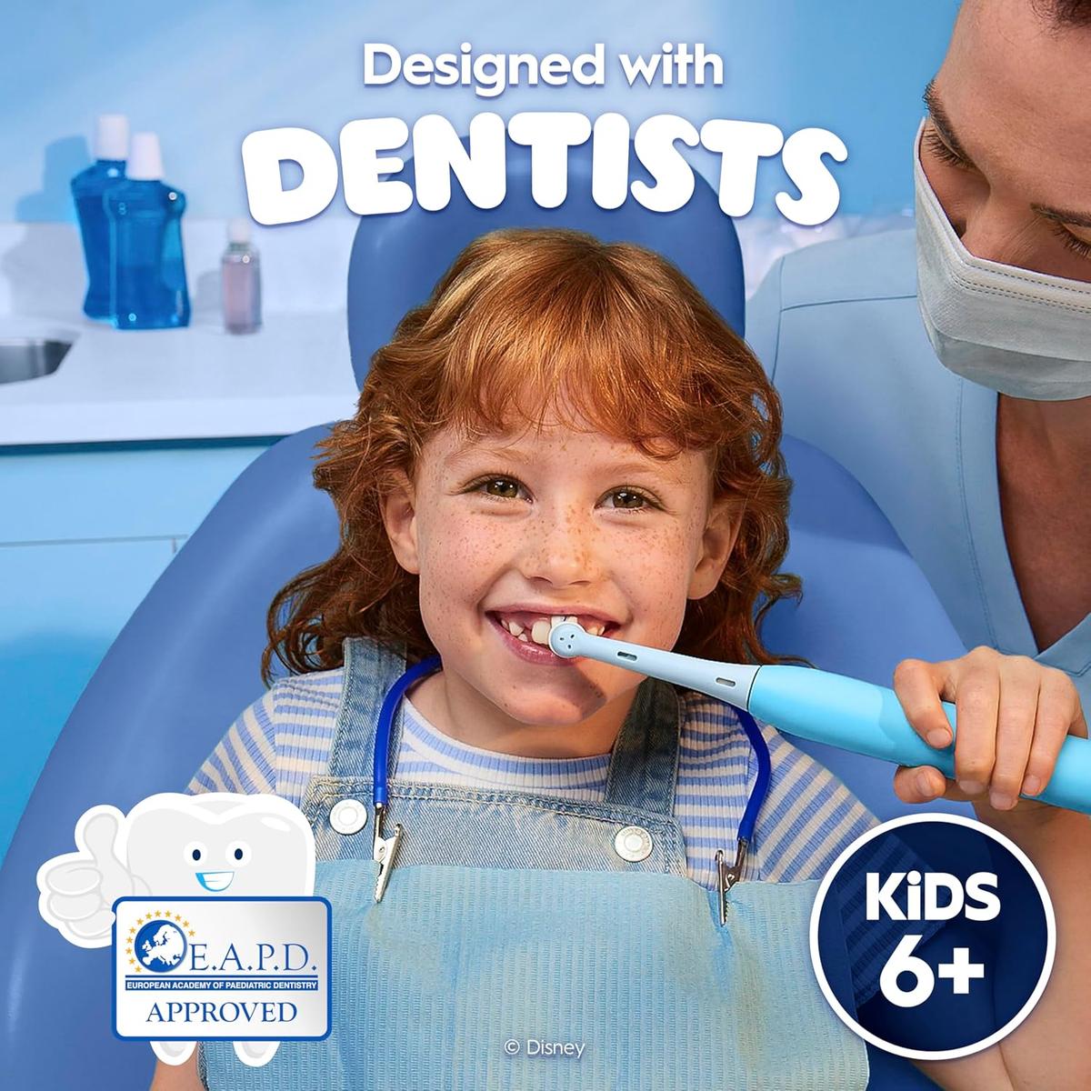 A young girl using a light blue Oral-B iO electric toothbrush during a dentist visit, featuring E.A.P.D. approval.